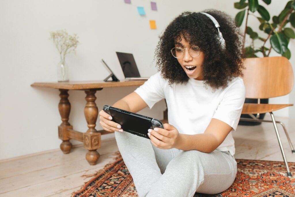 Woman enjoying video game on handheld console indoors, casual setting.